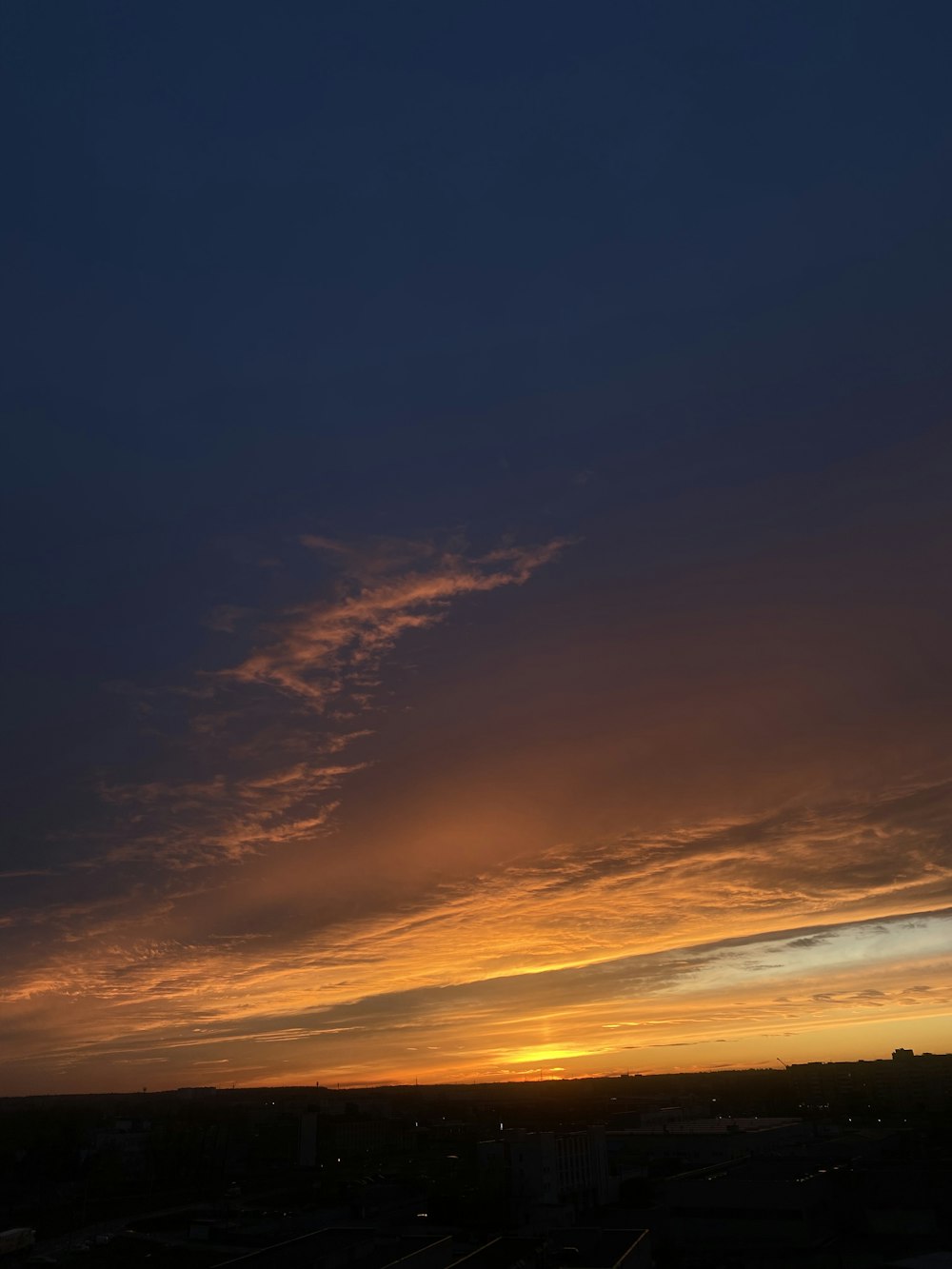 a plane flying in the sky at sunset