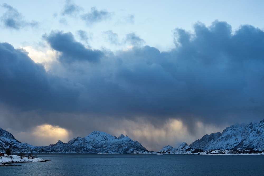 a large body of water surrounded by snow covered mountains