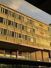 Modern office building with golden accents reflecting sunlight.