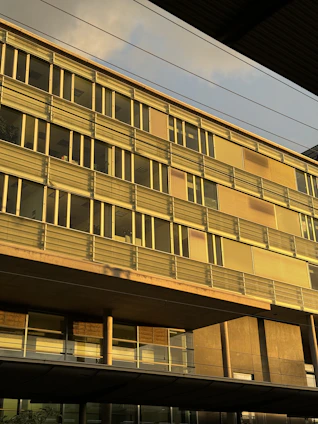 Modern office building with golden accents reflecting a sunrise, symbolizing growth and trust.