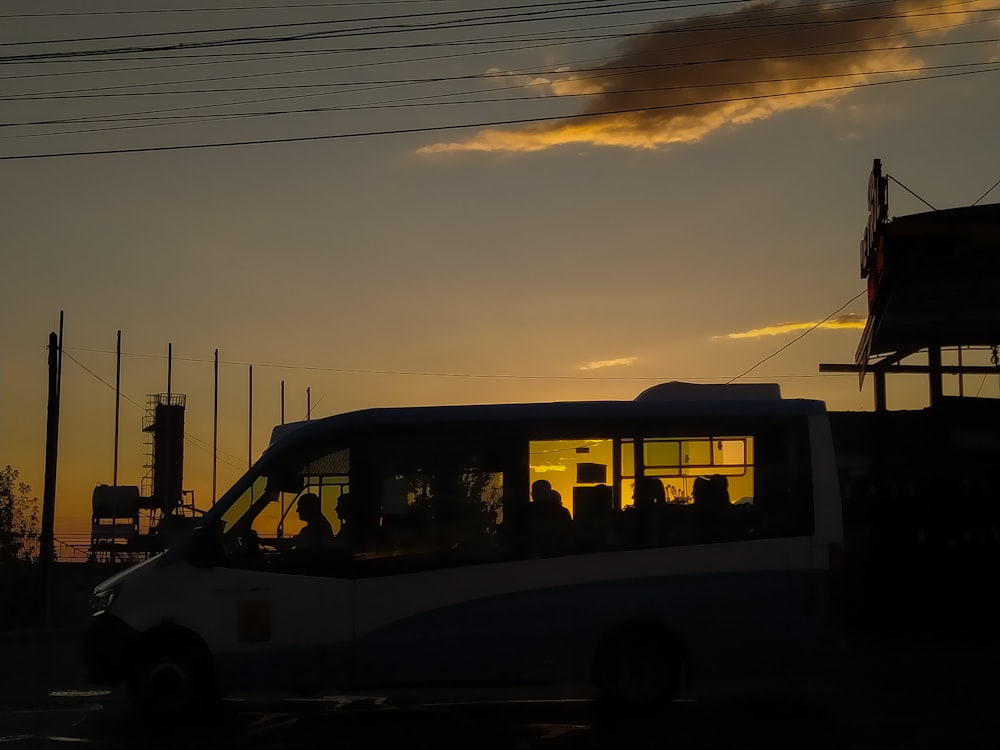 a bus driving down a street at sunset