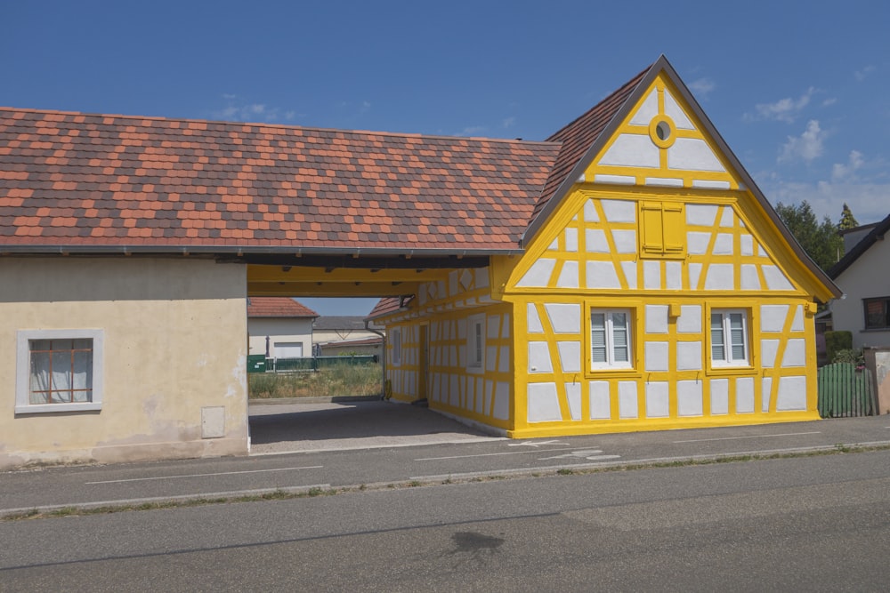 a yellow and white building with a red roof