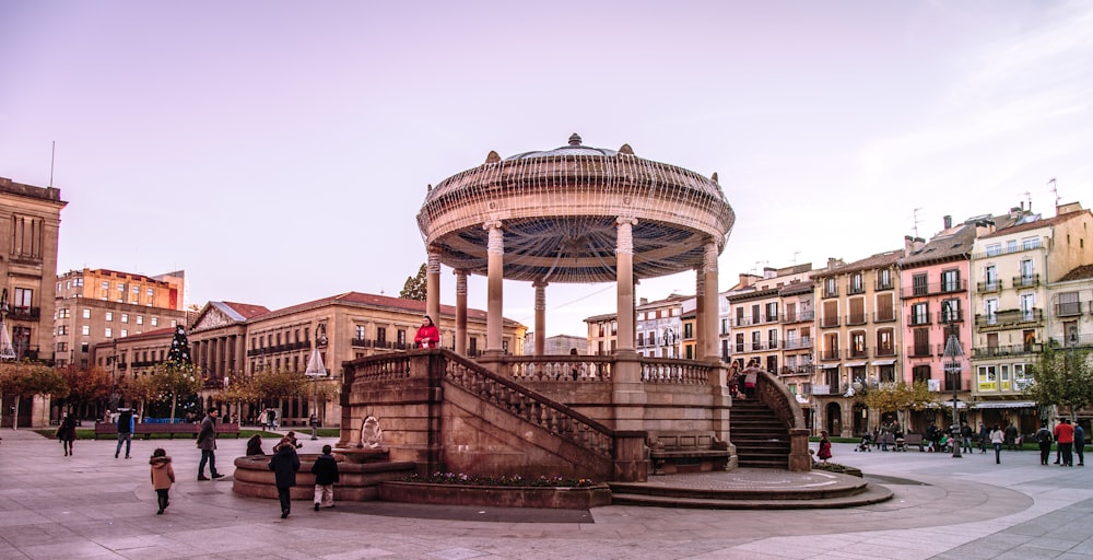 a group of people walking around a city square