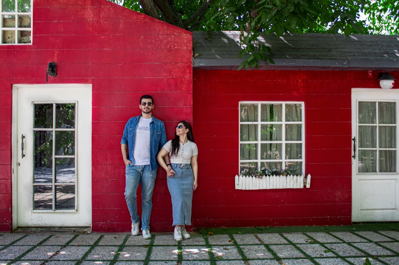 Couple smiling by red house