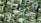 An array of 3D geometric shapes, including cylinders and rectangular prisms, arranged in a dense pattern. The shapes are predominantly in shades of green, creating a harmonious and uniform visual appearance.
