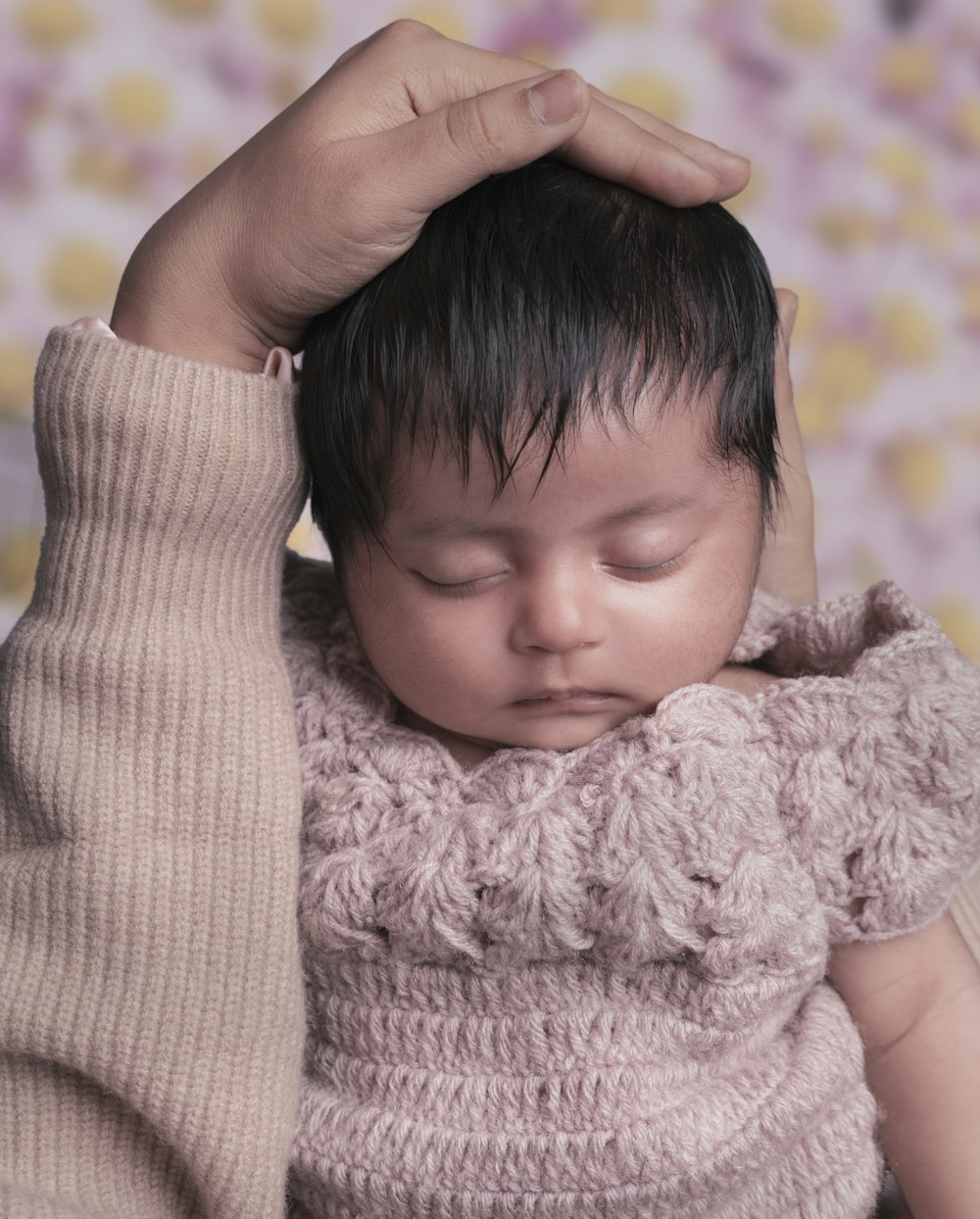 a baby is holding his head in his hands