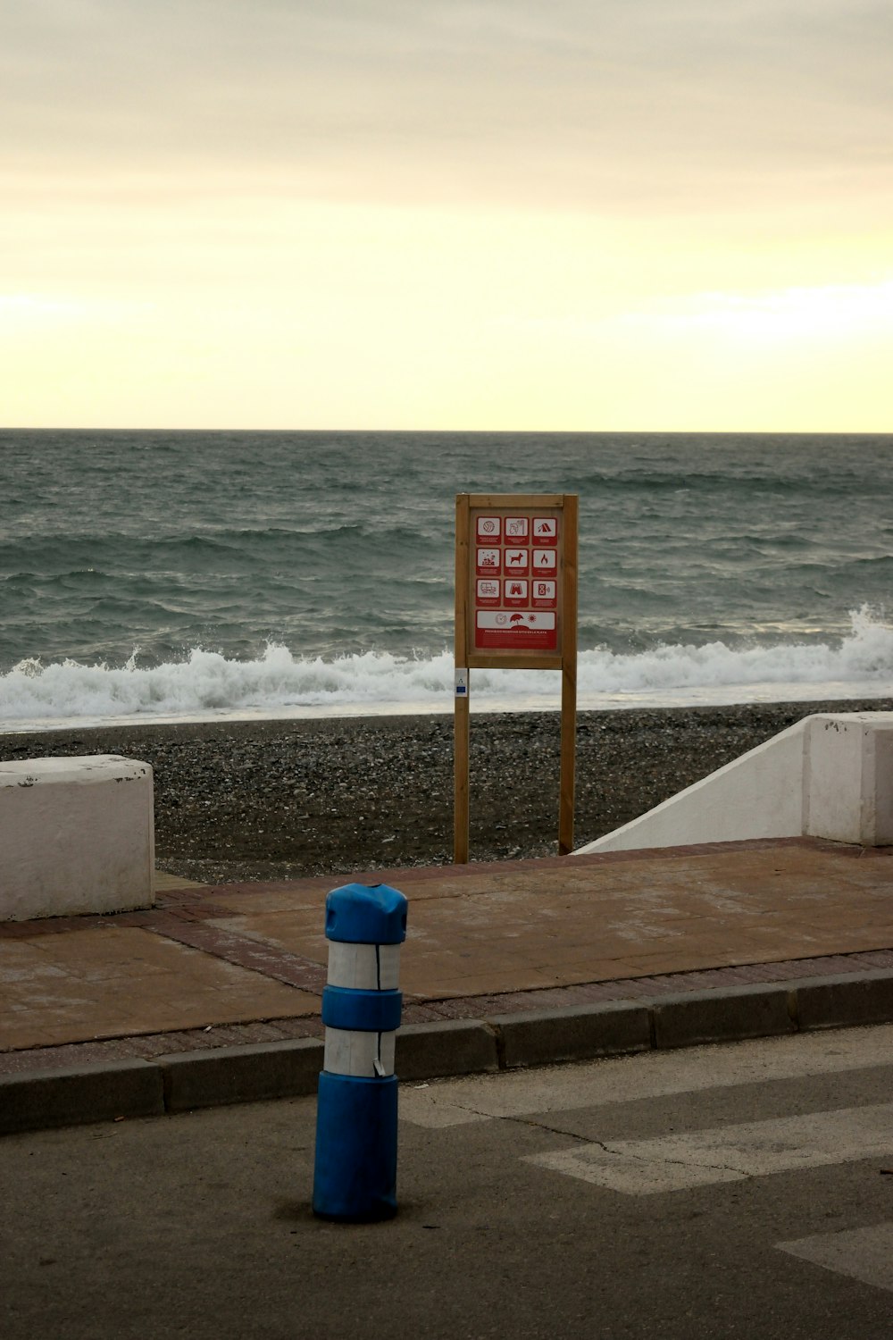 a blue and white buoy sitting on the side of a road