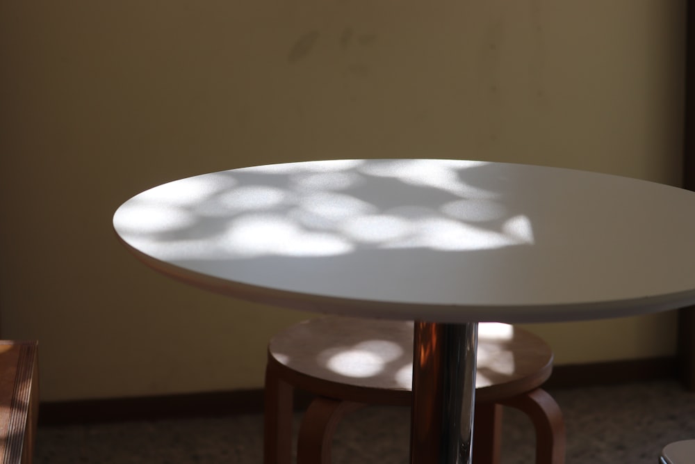 a white table and two stools in a room