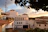 Illustration of a cozy Mediterranean apartment balcony overlooking the sea at sunset.