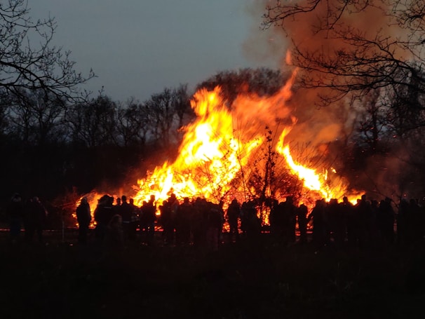 Evening bonfire gathering with family members sharing stories, the warm glow illuminating their faces.