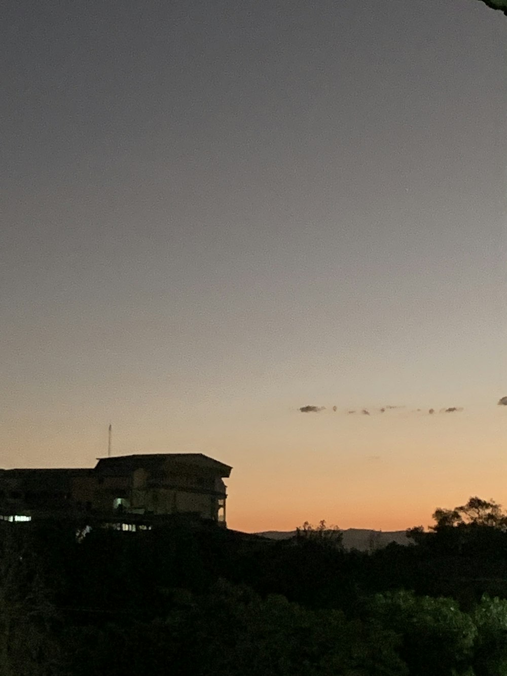 a kite flying in the air at sunset