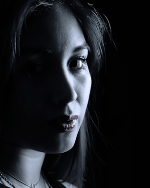 A close-up of a camera lens capturing a striking portrait with dramatic lighting.