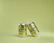 Two metallic cans with branding are positioned against a light green background. One can is slightly tilted and leaning against the other.