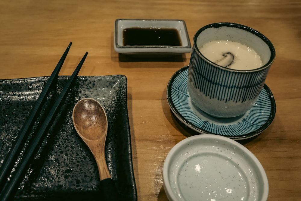 a wooden table topped with plates and bowls filled with food