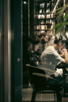 A diverse group of students studying together in a cozy environment, surrounded by books and laptops.