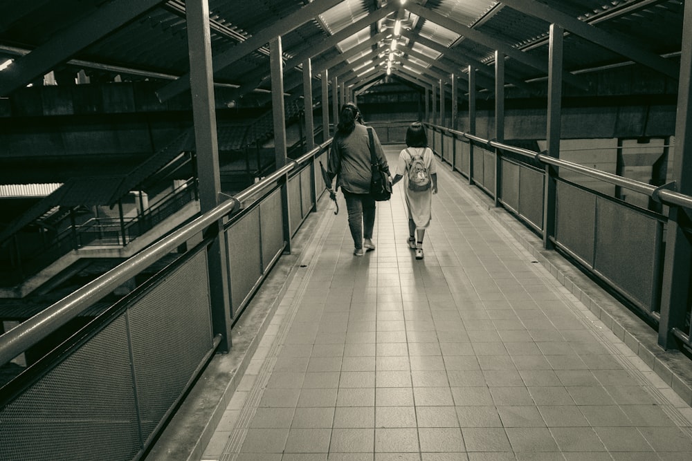 a couple of people that are walking down a walkway