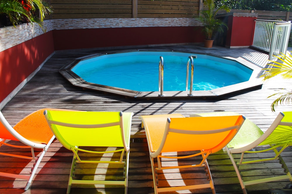 a pool with a hot tub and chairs around it