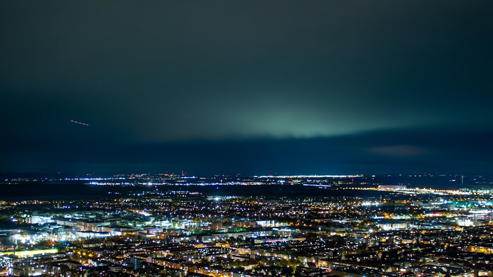 Una vista de una ciudad por la noche desde la cima de una colina