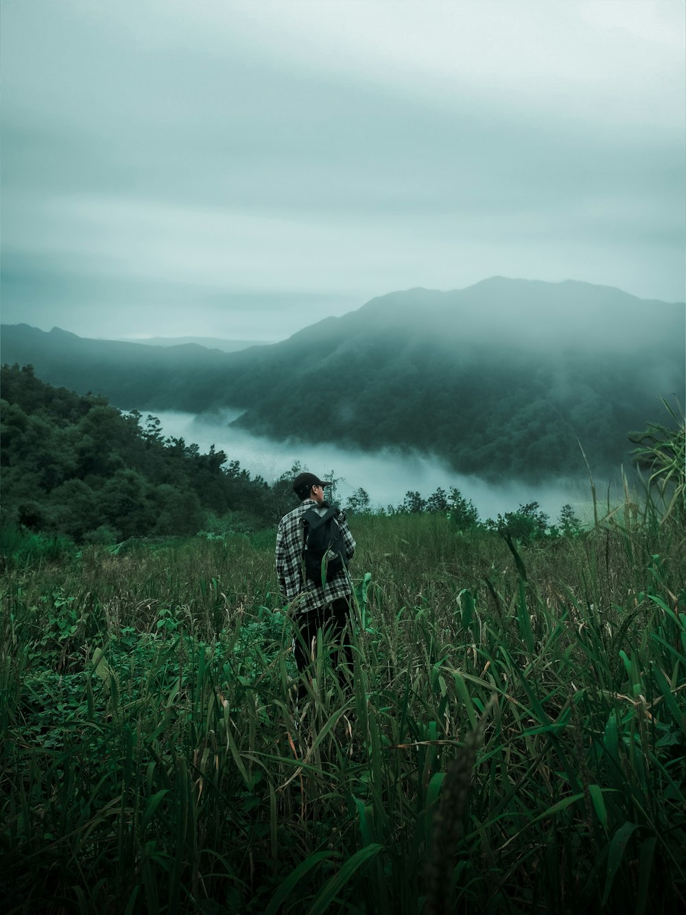 a man standing on top of a lush green field