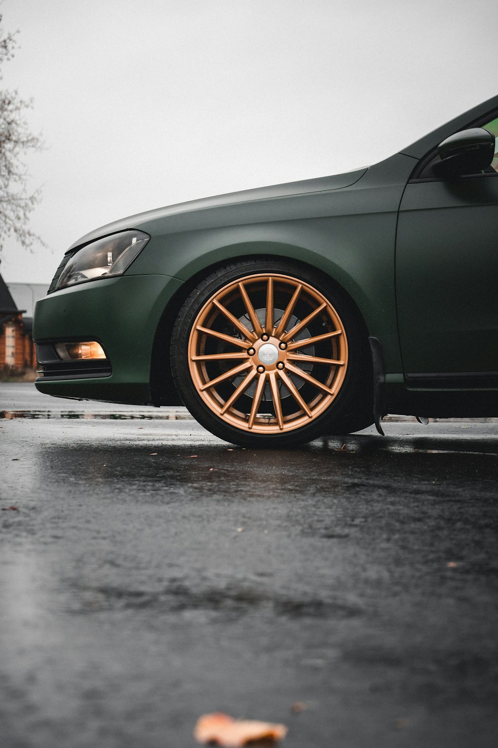 a green car parked on a wet street