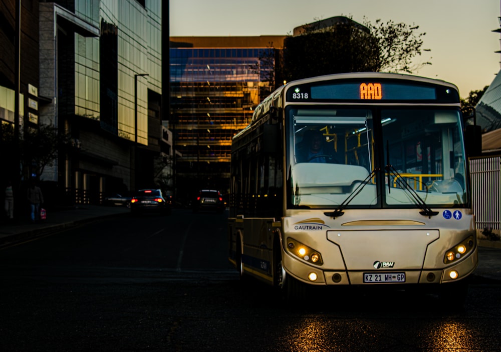 a bus driving down a street next to tall buildings