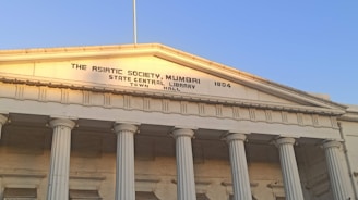 Historic building of Maharashtra Cosmopolitan Education Society campus bathed in warm morning light.