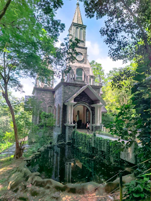 A serene old meeting house surrounded by lush greenery under a soft morning light