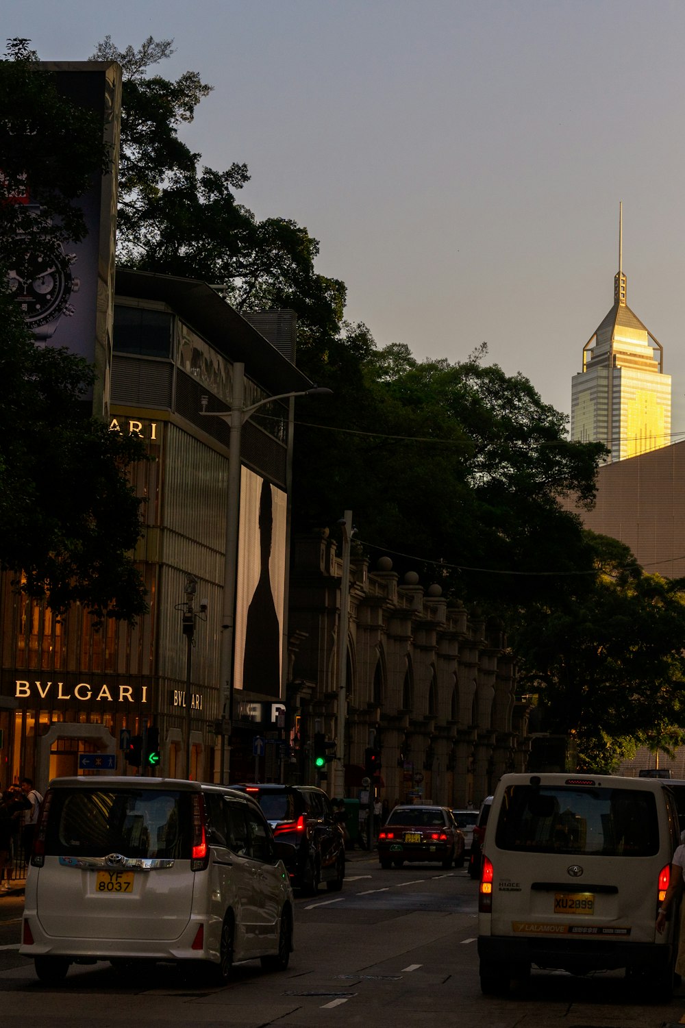 a city street filled with traffic next to tall buildings