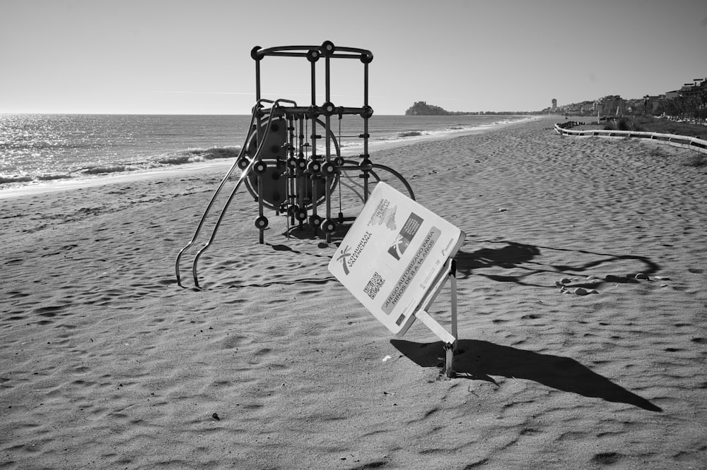 a black and white photo of a sign on a beach