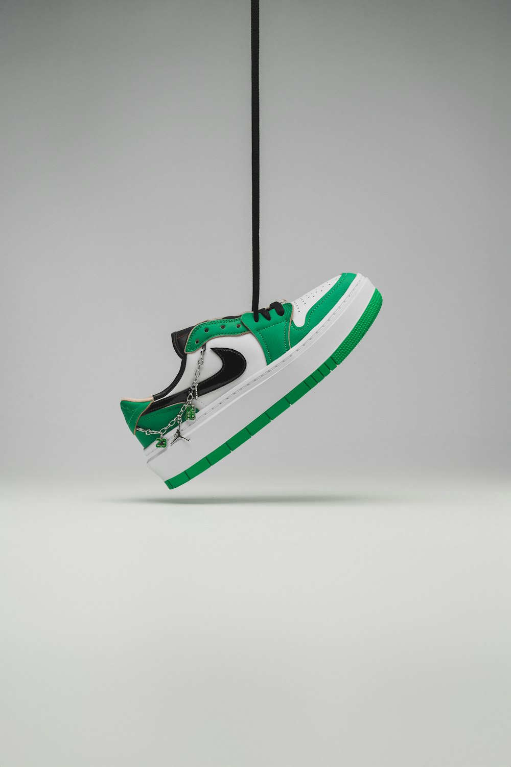 a pair of green and white sneakers hanging from a hook