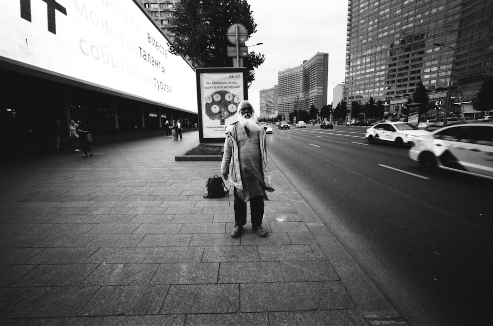 a man walking down a street next to a tall building