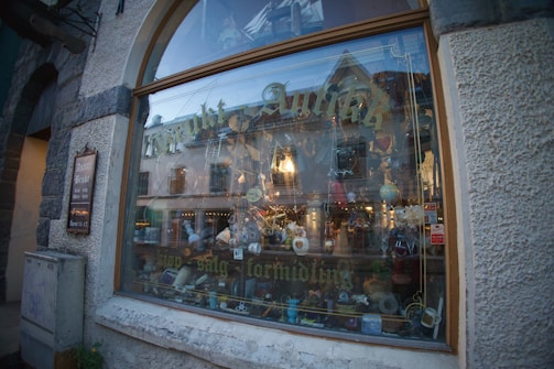 A colorful display of handmade crafts arranged in a small shop window.