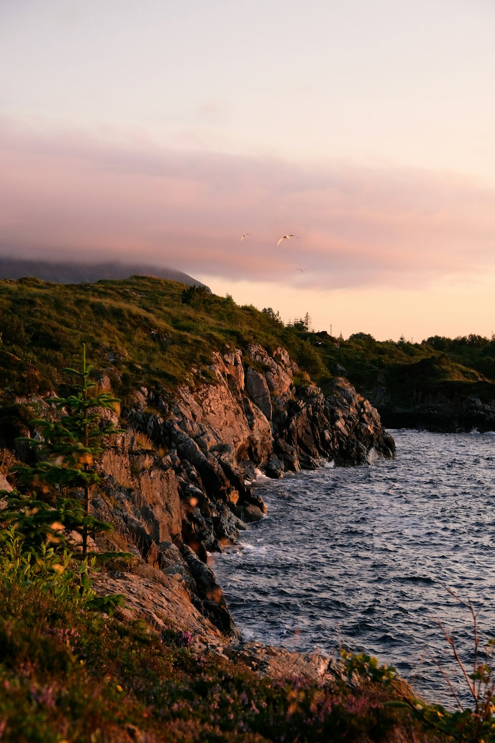 a body of water near a rocky cliff