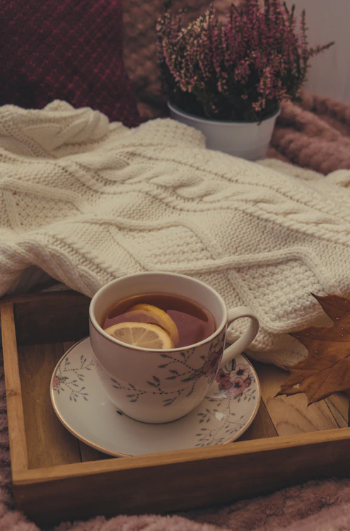 a tray with a cup of tea and a leaf on it