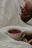 A cozy morning scene with a steaming cup of tea on a wooden table beside a soft cream-colored blanket.