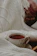 A cozy morning scene with a steaming cup of tea on a wooden table beside a soft cream-colored blanket.
