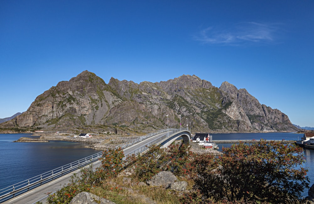 a bridge over a body of water with mountains in the background