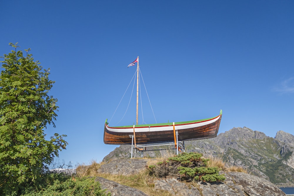 a boat sitting on top of a hill next to a lake