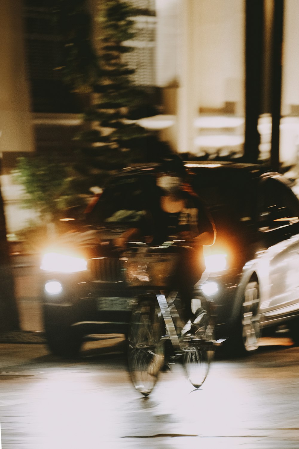 a man riding a bike down a street next to a car