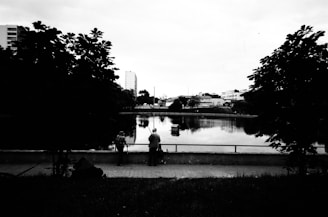 a man sitting on a bench next to a lake