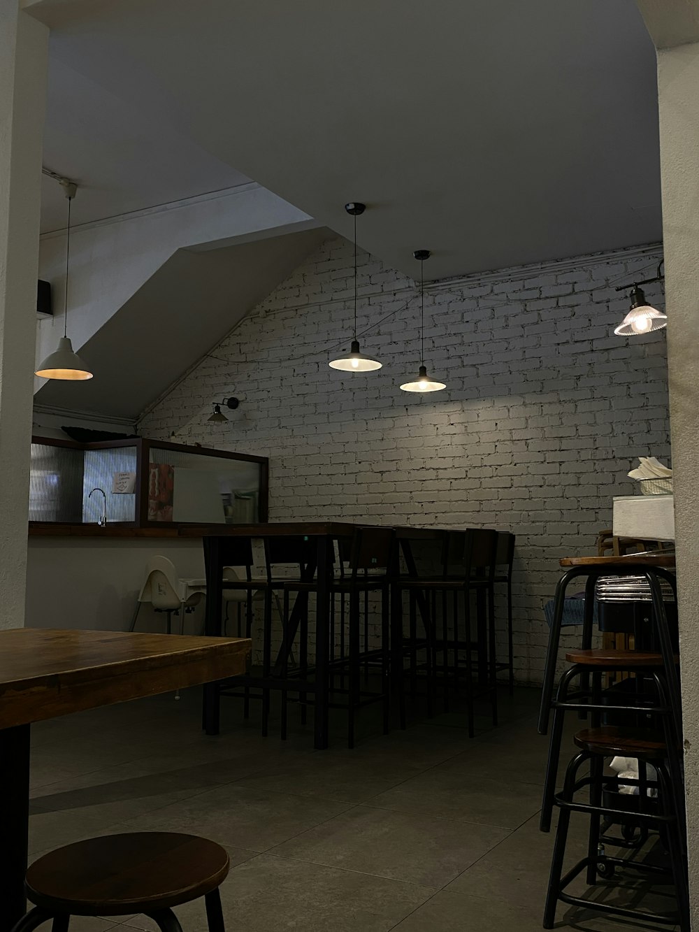 a room with a brick wall and several stools