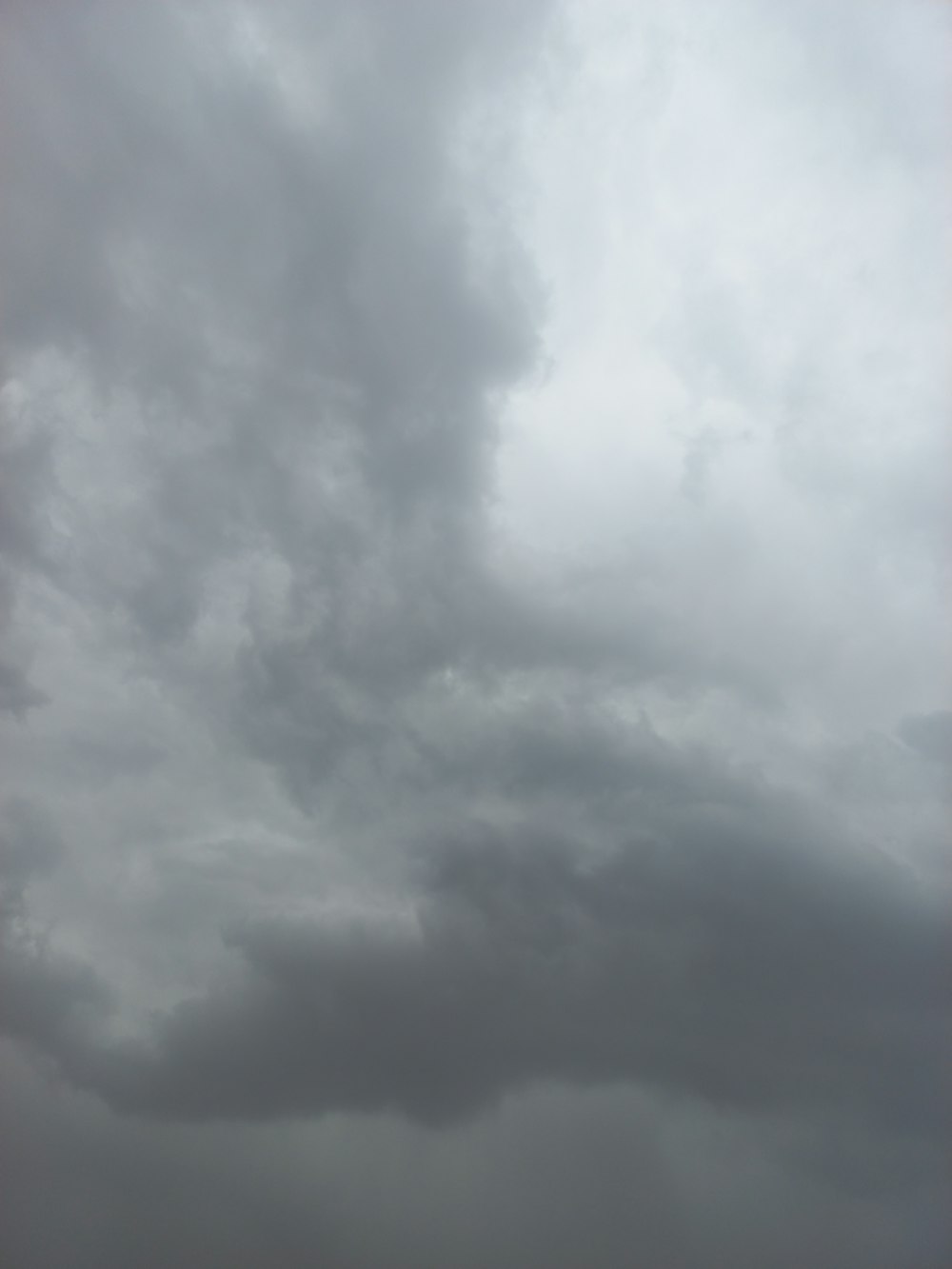 a group of people standing on top of a beach under a cloudy sky