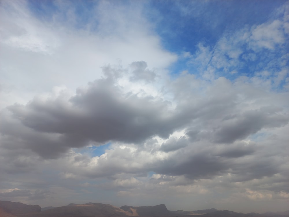 a view of a mountain range with clouds in the sky