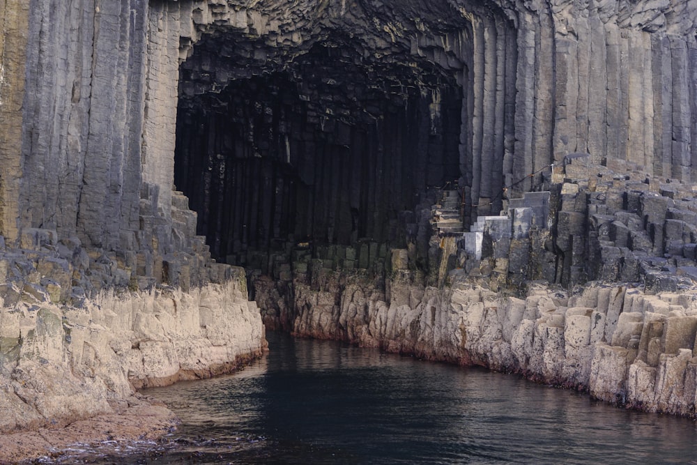 a cave with a body of water in front of it