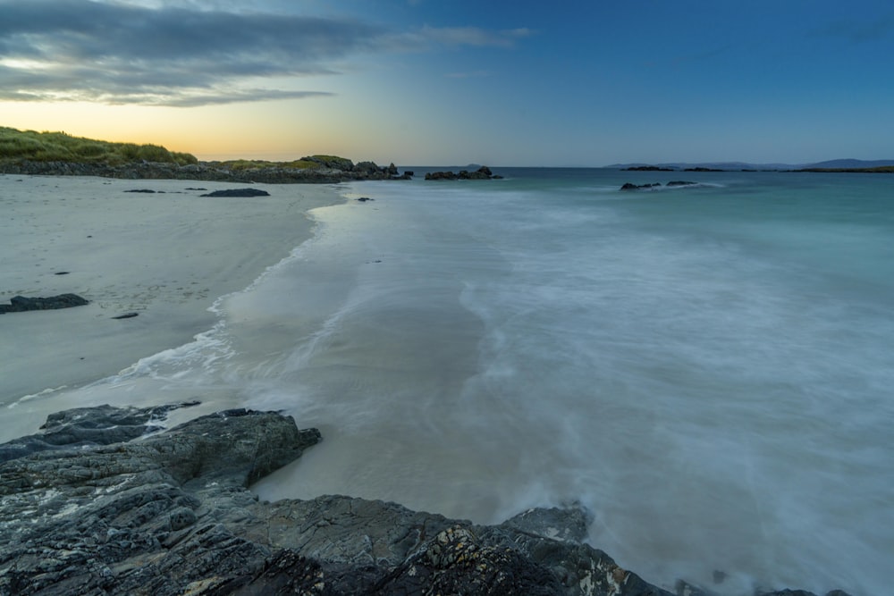 a sandy beach with waves coming in to shore