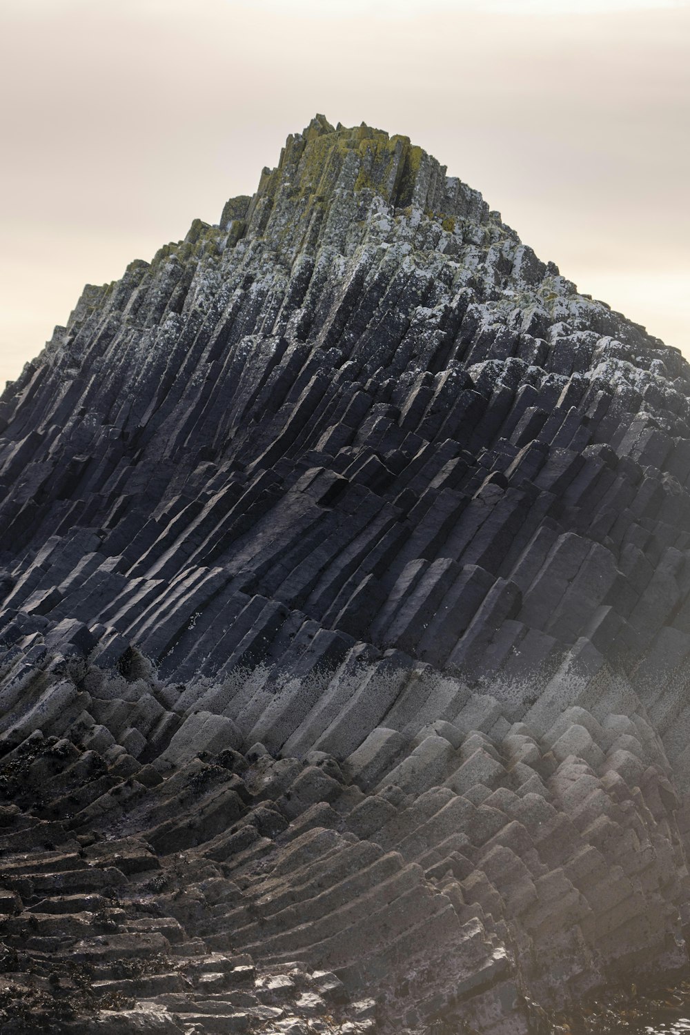 a large rock formation with a mountain in the background
