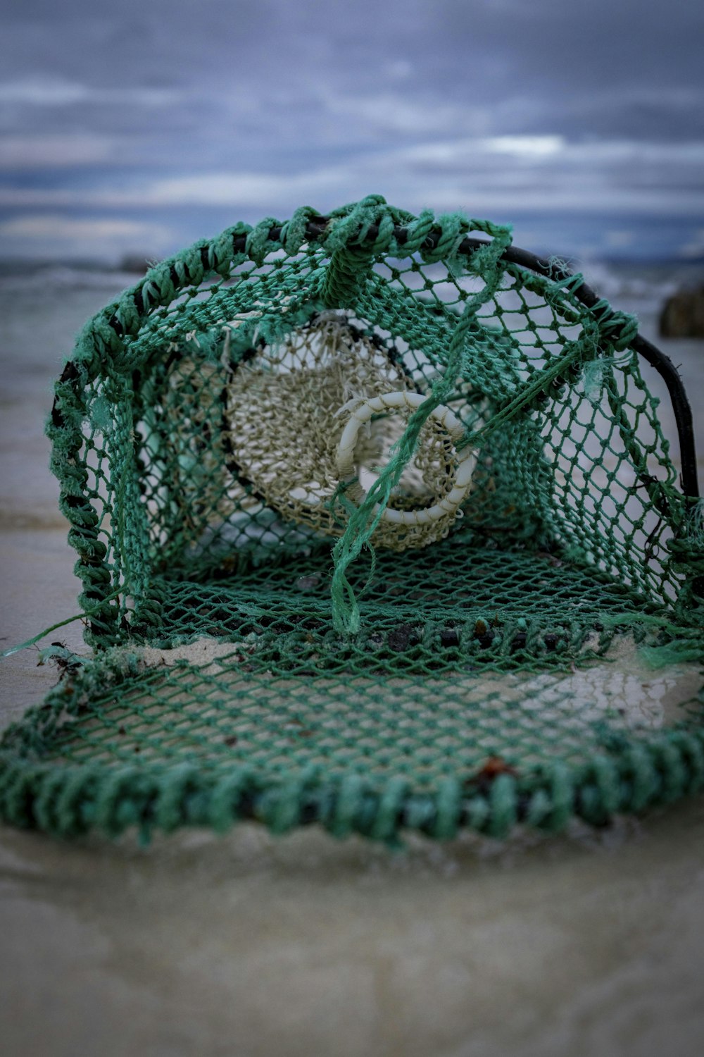 a green chair sitting on top of a sandy beach