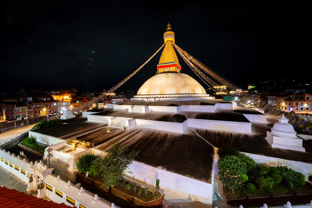 a large white building with a yellow roof at night