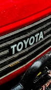 a close up of a toyota logo on a red car