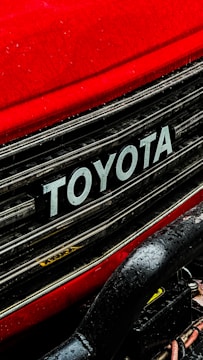 a close up of a toyota logo on a red car